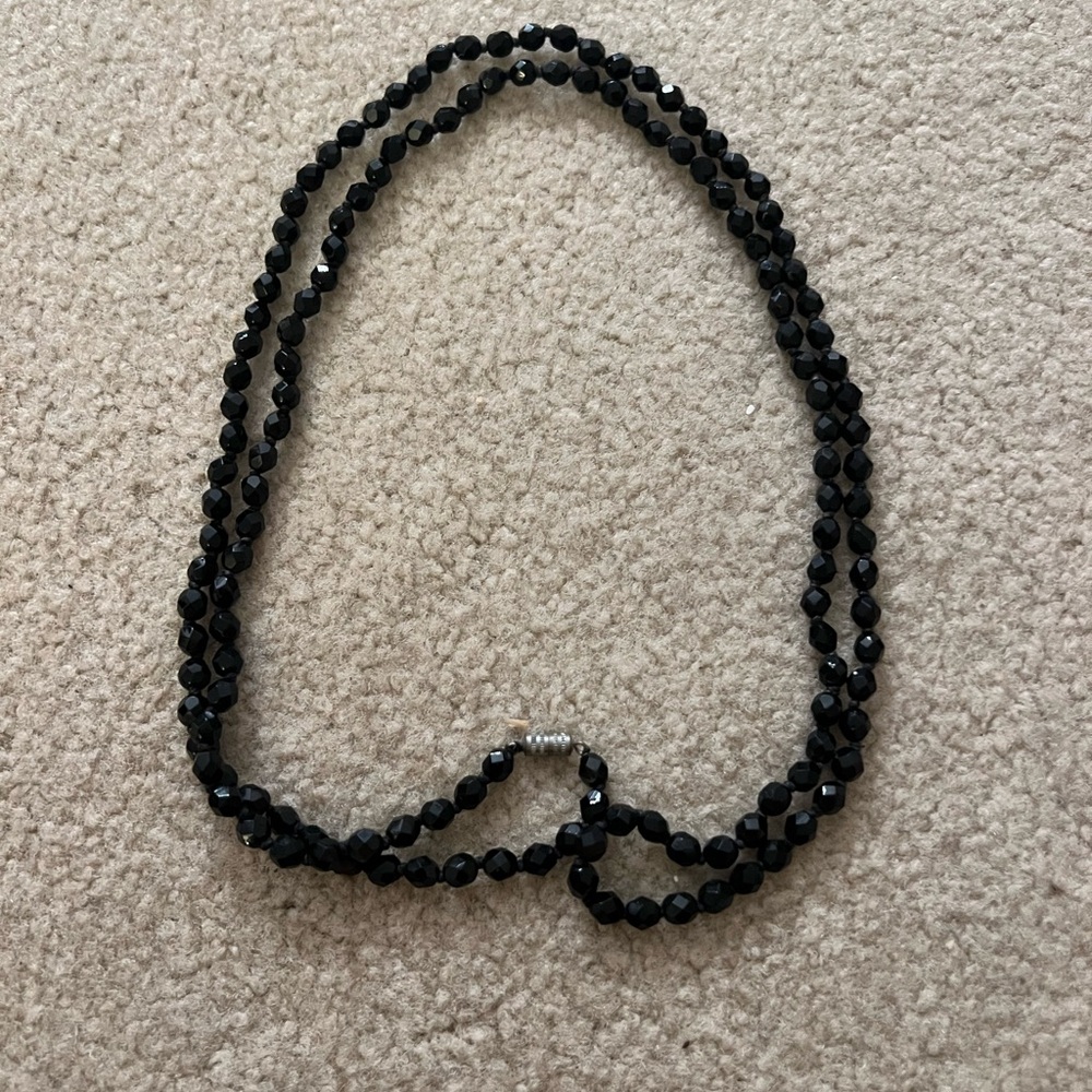 Very long chain made of black stones.